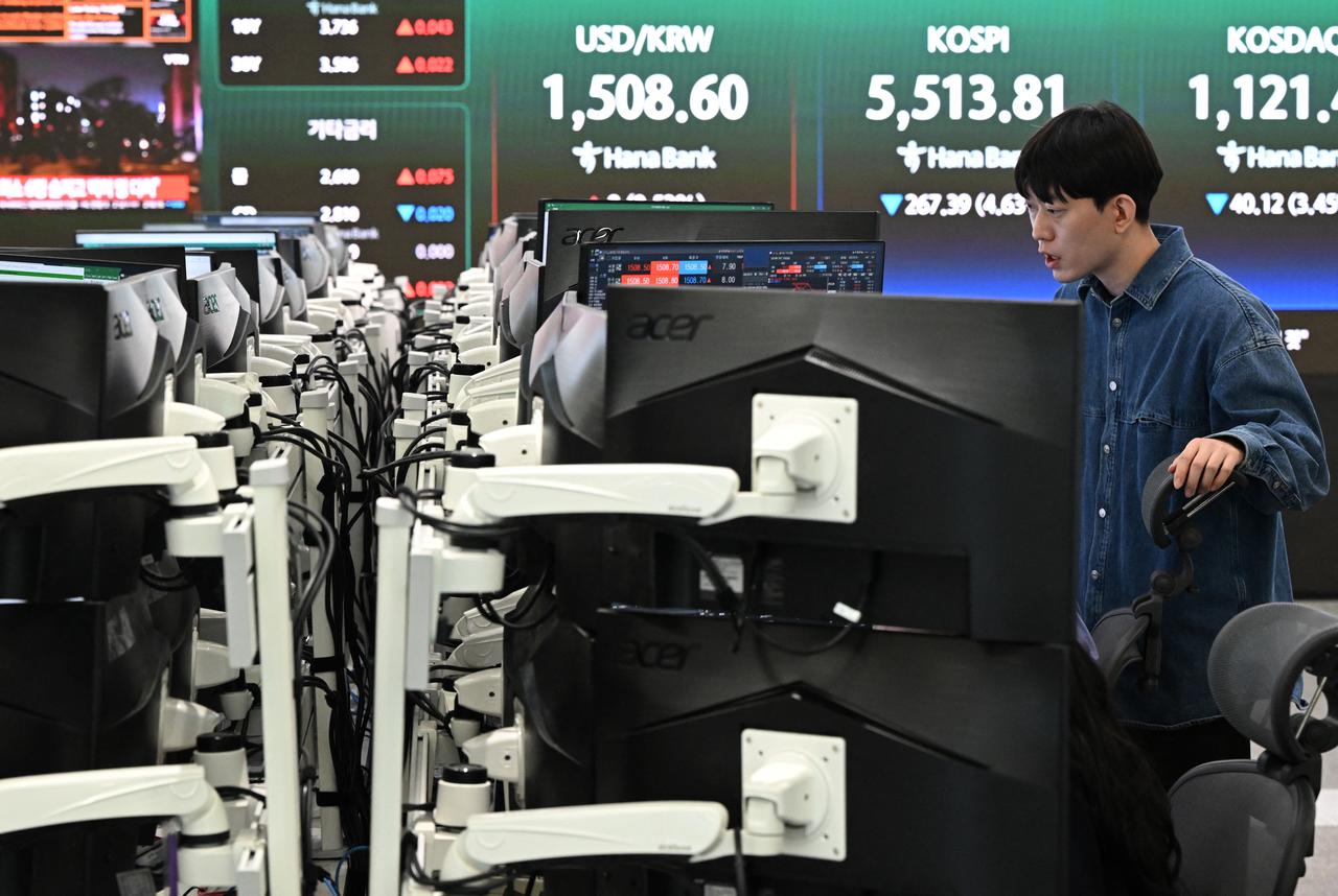 A currency dealer monitors exchange rates as a screen shows South Korea's benchmark stock index (KOSPI) and the Korean won/USD exchange rate (C) in a foreign exchange dealing room at the Hana Bank headquarters in Seoul, South Korea, March 23, 2026. (AFP Photo)