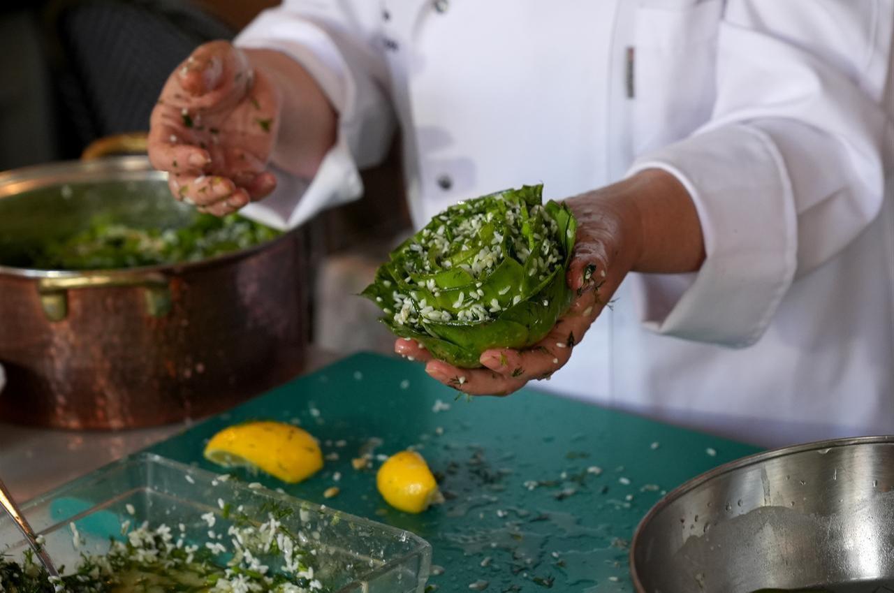 Rice mixed with herbs is carefully stuffed between the leaves of an artichoke while preparing traditional olive oil artichoke dolma in Izmir, Türkiye, March 16, 2026. (AA Photo)