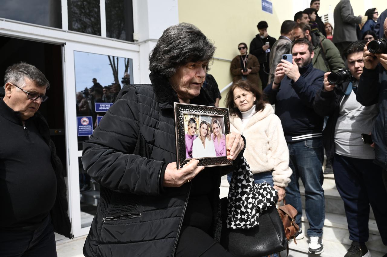 A relative holds a victim's picture at the "Gaipolis" conference venue as the trial opens over the deadly Tempi train crash, Larissa, Greece, March 23, 2026. (AFP Photo)