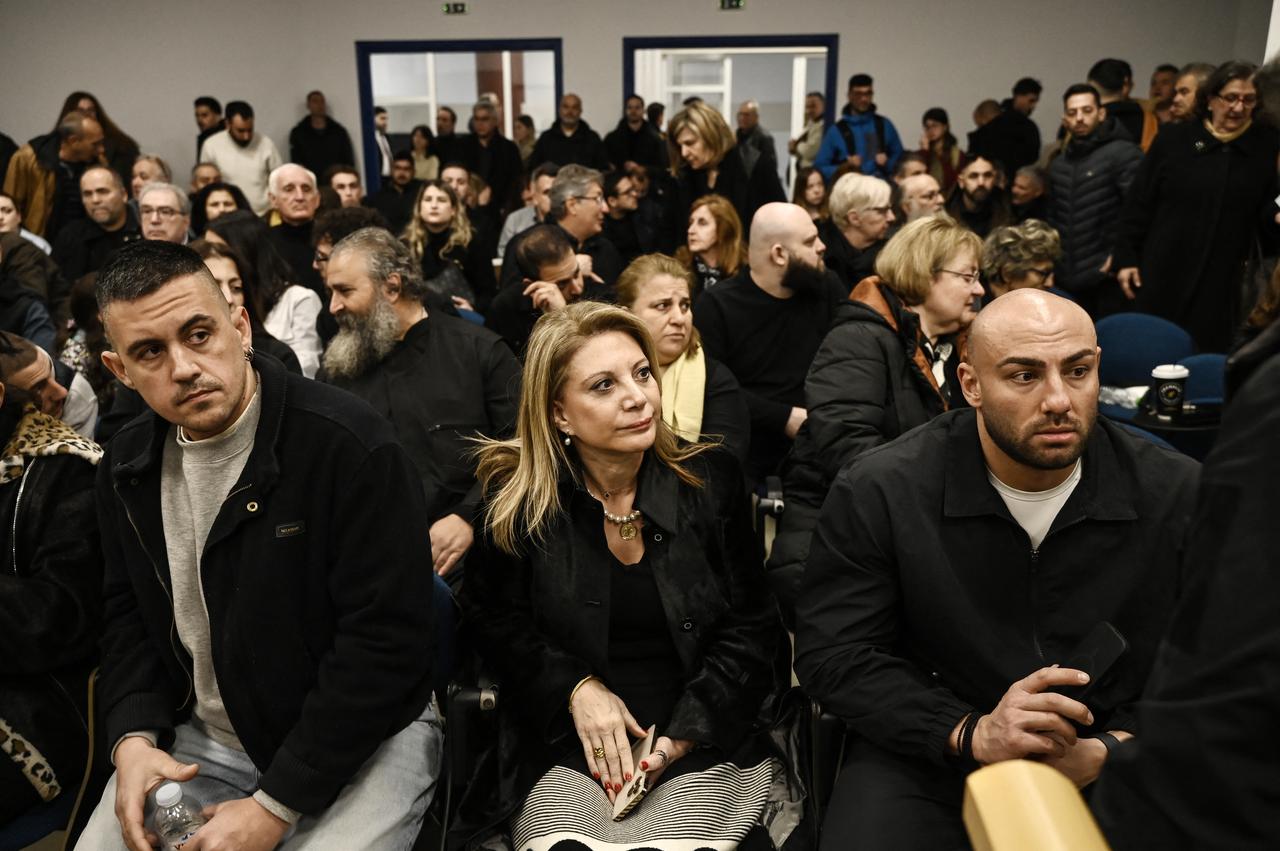 Former Tempi 2023 Victims' Association president Maria Karystianou (C) sits with relatives inside the conference venue as the trial opens, Larissa, Greece, March 23, 2026. (AFP Photo)