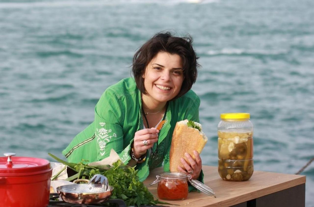 Chef Refika Birgul prepares and serves a fish sandwich by the Bosphorus during an outdoor cooking session, Istanbul, Türkiye, March 13, 2026. (Instagram /@refikabirgul)