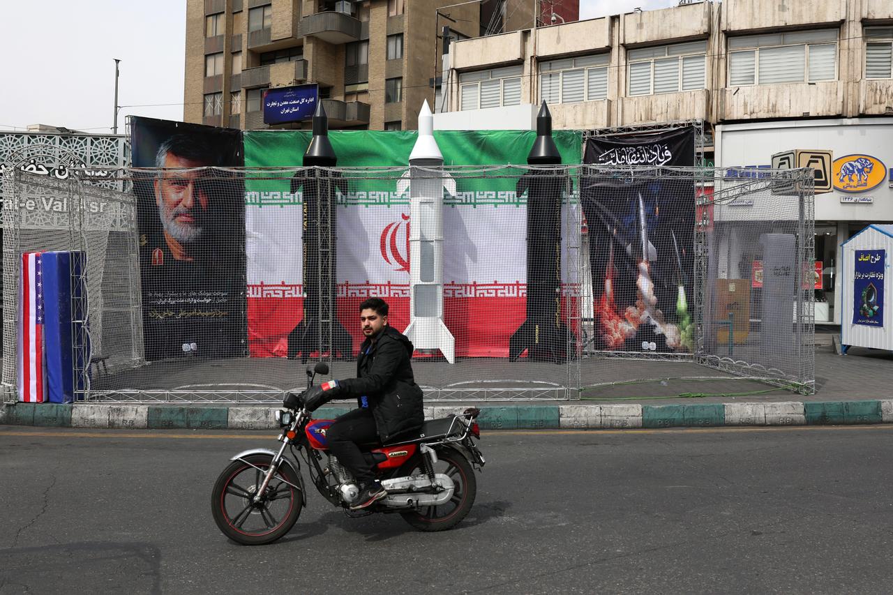 A motorist rides past the dummy models of Iranian missiles installed along the roadside at the Valiasr Square, in Tehran, Iran on March 22, 2026. (AFP Photo)