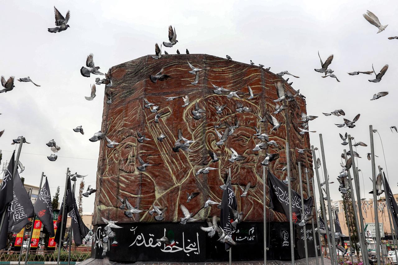 Birds fly near a monument in Enghelab (Revolution) Square in central Tehran on March 25, 2026. Iran fired cruise missiles at the USS Abraham Lincoln aircraft carrier, the military said on March 25 in a statement carried by state television, warning of further launches when the strike group's ships come in range. (AFP Photo)