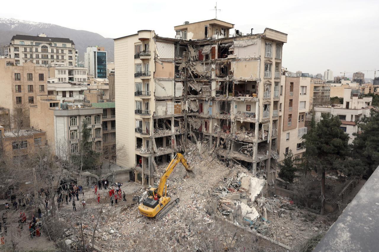 An excavator clears rubble from destroyed residential buildings in northern Tehran, Iran, March 23, 2026. (AFP Photo)