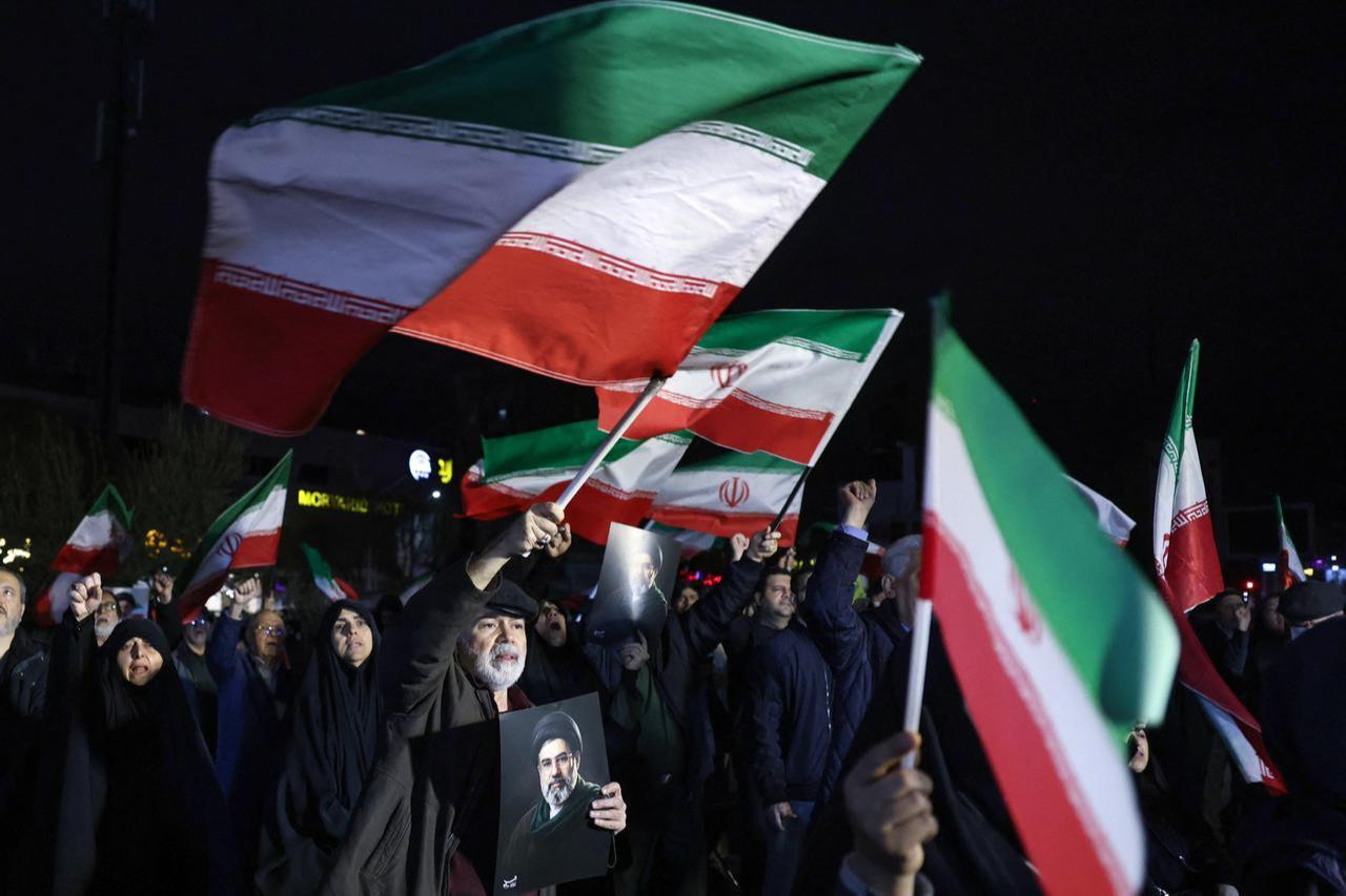 People wave national flags and hold portraits of Iran's supreme leader Mojtaba Khamenei as they march in support of the Iranian armed forces in central Tehran, Iran on March 25, 2026. (AFP Photo)