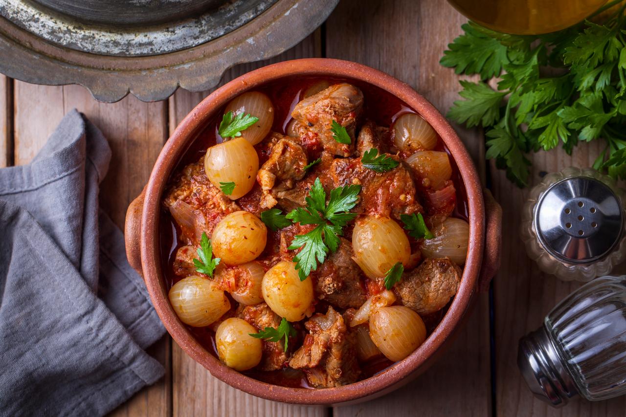 Whole, smothered onions and tender beef in a rich tomato and spice sauce, prepared with the patience required for a true Mediterranean classic. (Adobe Stock Photo)