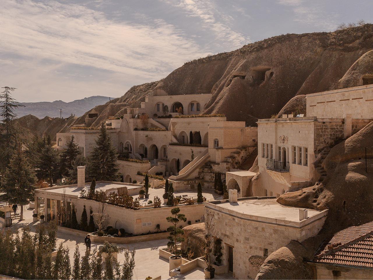 Avantgarde Refined Caves of Cappadocia is seen carved into the volcanic rock landscape of Urgup, blending historic cave architecture with contemporary design. (Photo via TIME)