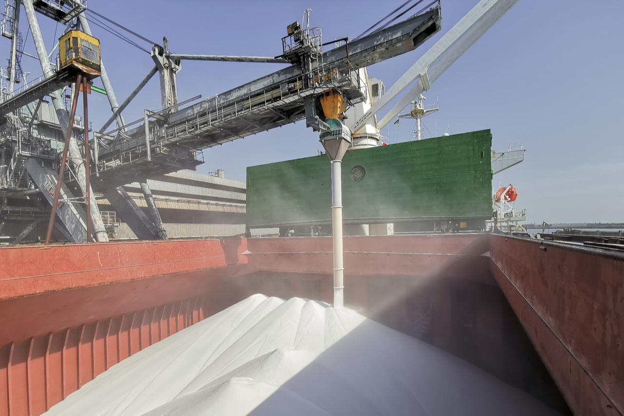 Urea fertilizer being loaded onto a cargo vessel at a port facility. (Adobe Stock Photo)