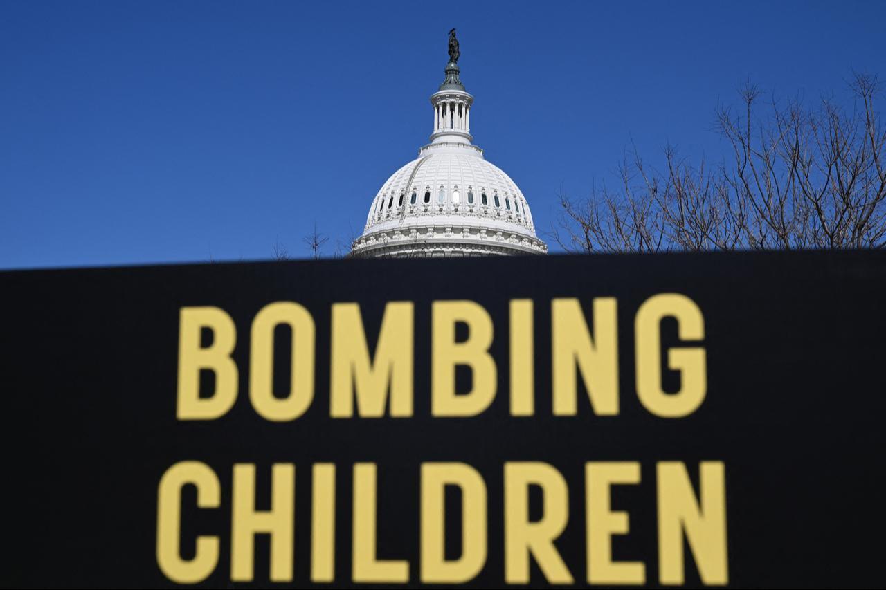 A memorial made up of signs, shoes and backpacks symbolizing those killed in the bombing of the Minab elementary school and other civilians killed in Iran sits outside the United States Capitol, March 18, 2026 in Washington, DC. (AFP Photo)