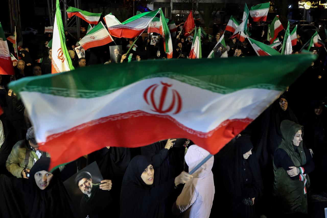 People wave national flags and hold portraits of Iran's supreme leader Mojtaba Khamenei as they march in support of the Iranian armed forces in central Tehran, March 25, 2026. (AFP Photo)