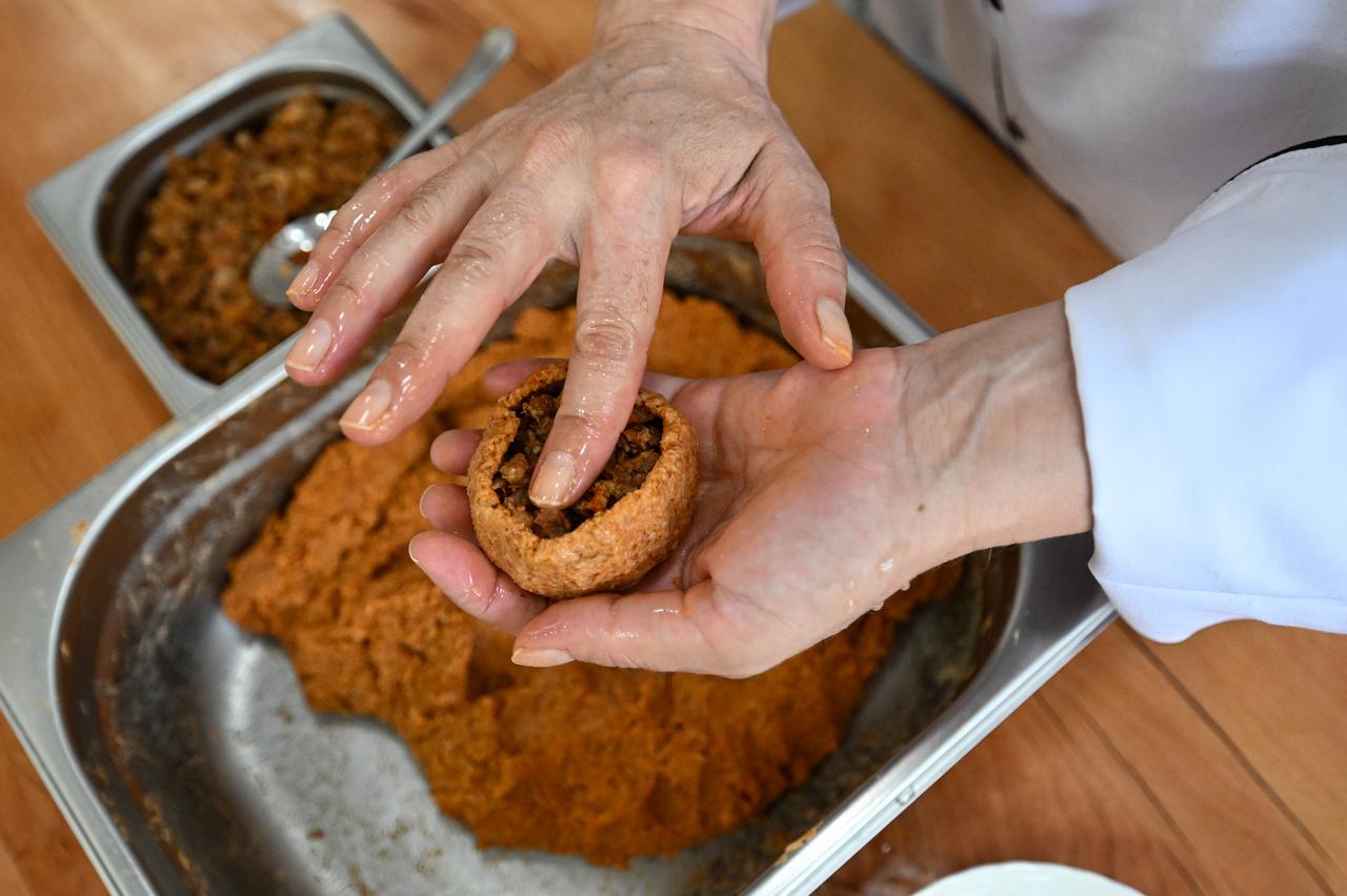 The filling is placed inside the hollowed bulgur mixture as part of the traditional preparation of Adana icli kofte in Adana, Türkiye, March 3, 2026. (AA Photo)