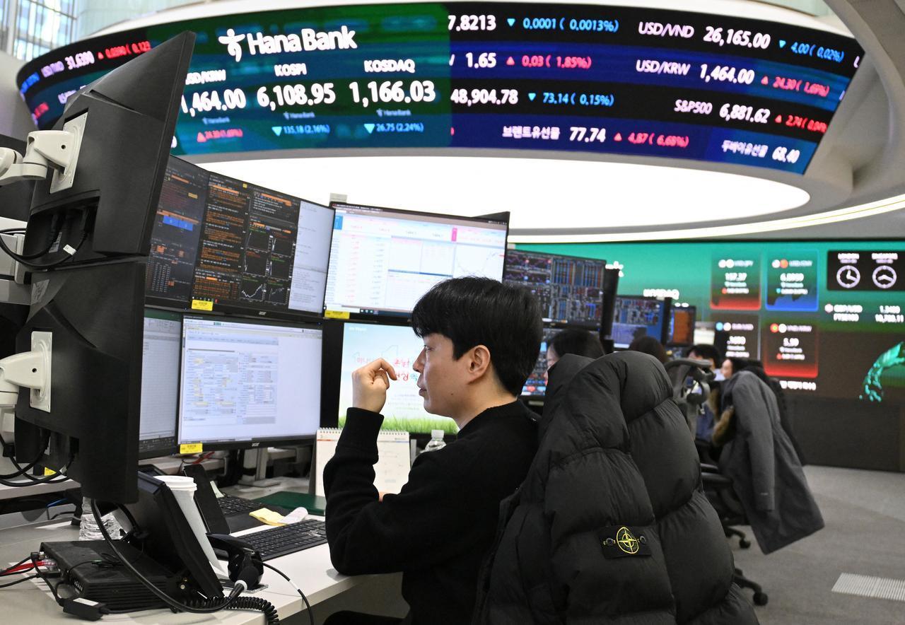 Currency dealers monitor exchange rates as an electronic screen shows South Korea's benchmark stock index (KOSPI) and the Korean Securities Dealers Automated Quotations (KOSDAQ) in a foreign exchange dealing room at the Hana Bank headquarters in Seoul, March 3, 2026. (AFP Photo)