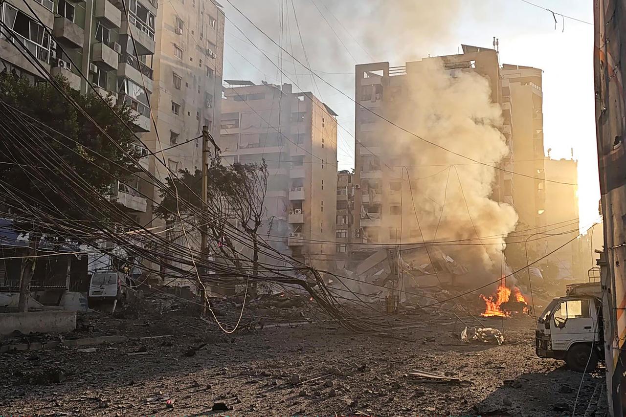 This frame grab from AFPTV video footage taken on March 3, 2026 shows smoke billowing from a fire and buildings damaged after an early morning Israeli strike on Beirut's southern suburbs. (AFP Photo)