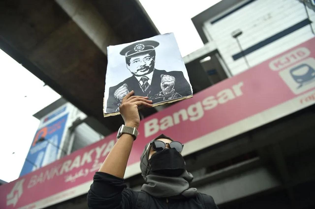 A protester holds up an image of MACC chief Azam Baki during an “Arrest Azam Baki” rally in Kuala Lumpur, Malaysia. (AFP Photo)