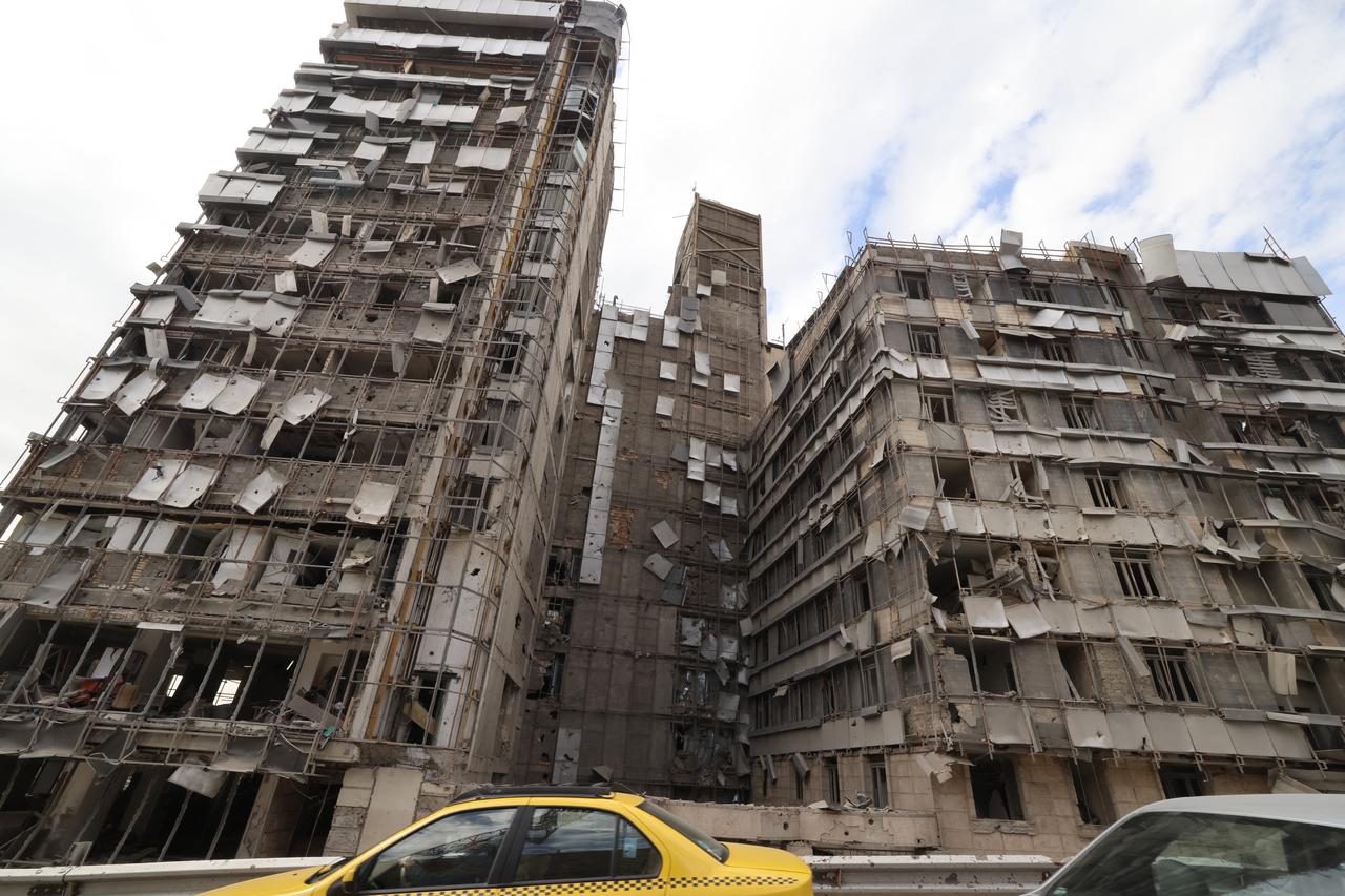 Cars drive past the damaged facade of the Gandi Hospital, which was hit on March 1, when a projectile struck a state TV communications tower and nearby buildings across the street, during a joint US-Israeli military campaign in the capital, Tehran, March 2, 2026. (AFP Photo)