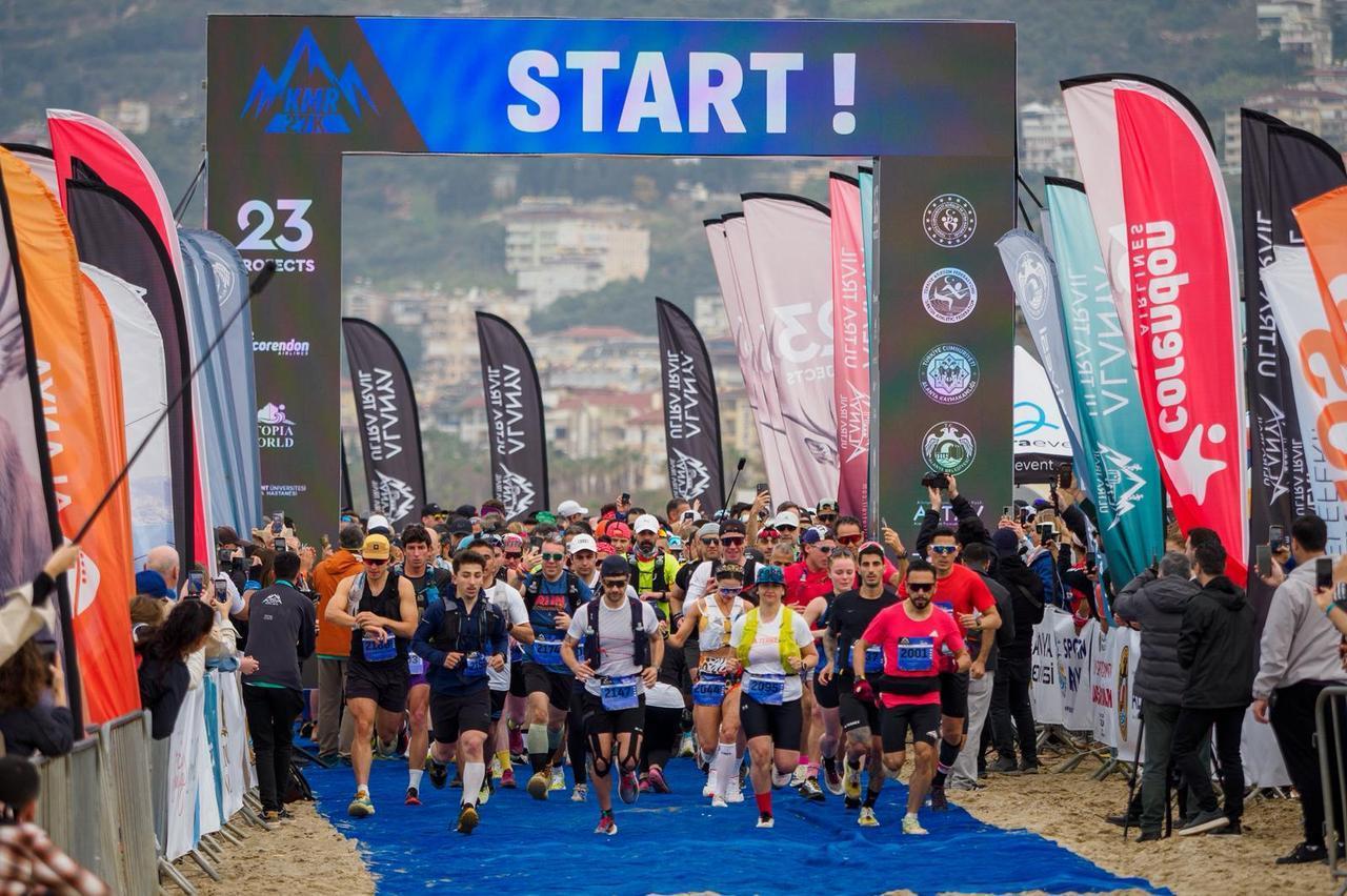 Runners surge forward at the start line beneath the “START!” arch during Alanya Ultra Trail, as hundreds of athletes set off from Cleopatra Beach, Alanya, Türkiye. (Photo via Alanya Ultra Trail)