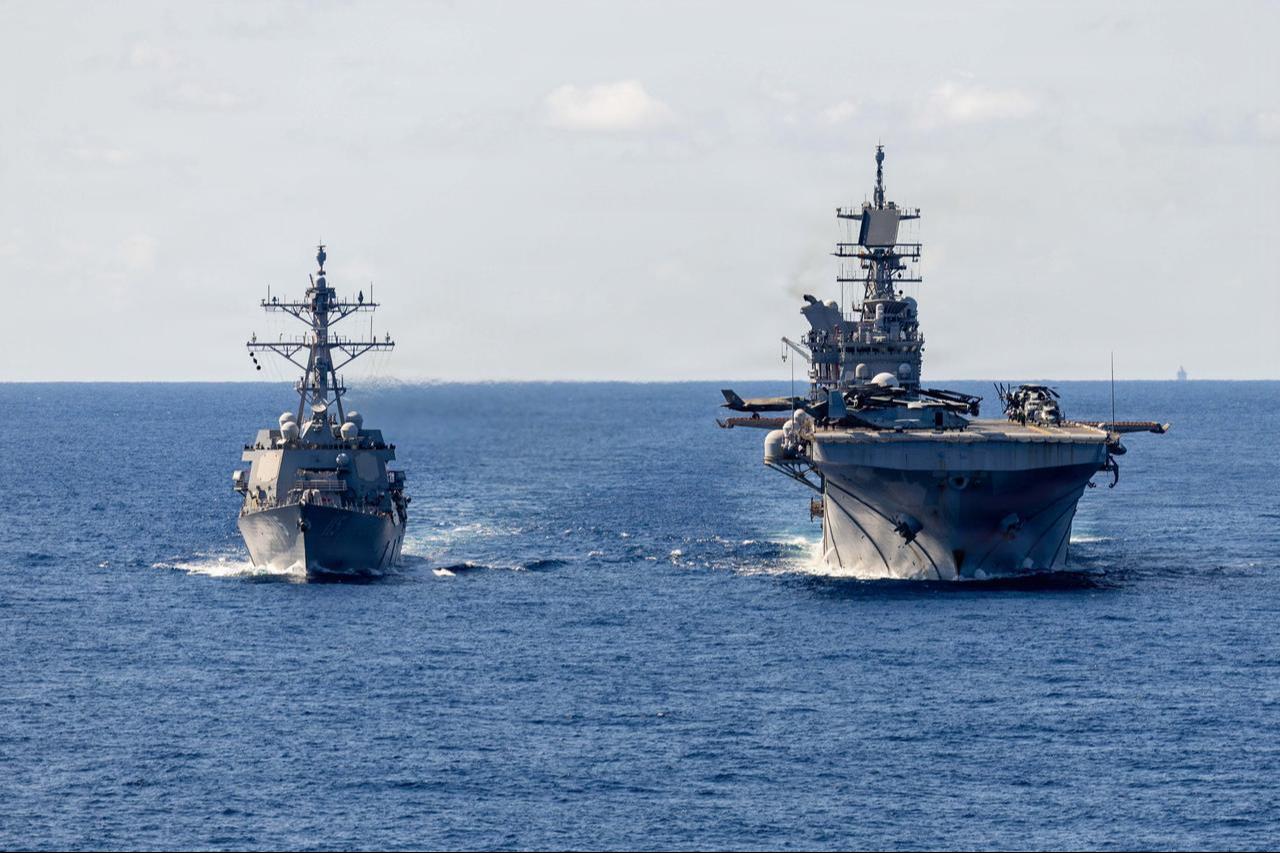 Arleigh Burke-class guided-missile destroyer USS Rafael Peralta (DDG 115) receives fuel from America-class amphibious assault ship USS Tripoli (LHA 7) during a replenishment-at-sea in the Philippine Sea. (Photo via X/@USNavy)