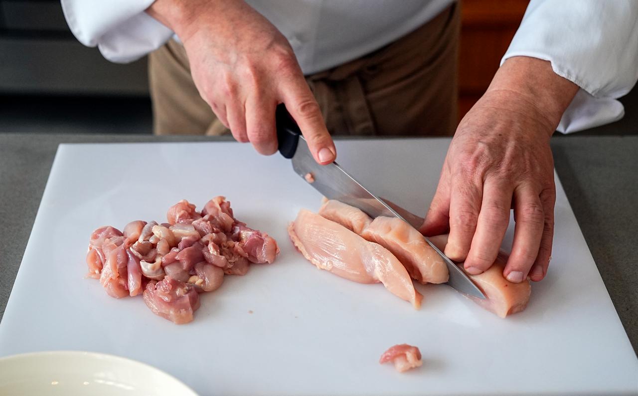 Chef Birkan Erkoylu chops chicken into small cubes as part of the preparation process for honeyed Mahmudiye, a traditional Ottoman palace dish, in Istanbul, Türkiye, March 4, 2026. (AA Photo)