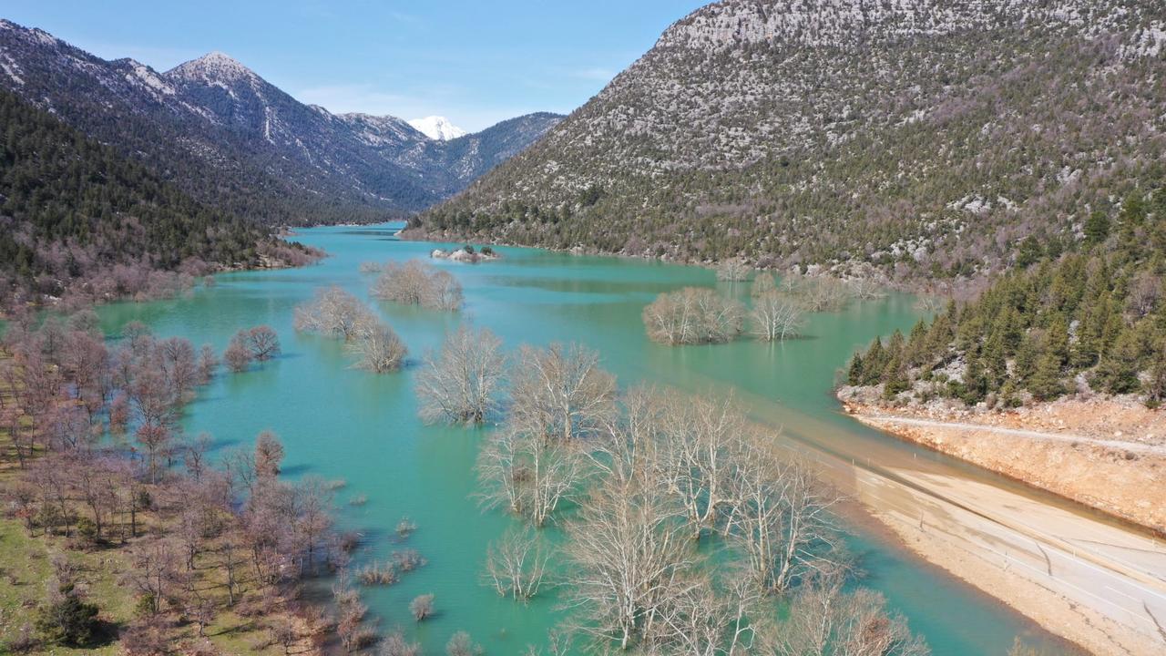 Partially submerged trees and rising waters surround sections of the Antalya–Konya highway as flooding spreads across the valley landscape, March 4, 2026. (IHA Photo)