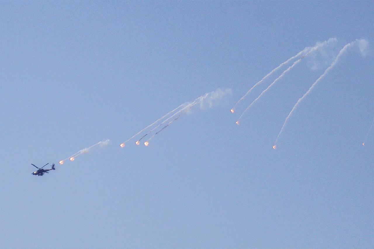 An Israeli Air Force AH-64 Apache attack helicopter releases flares while flying over the southern Lebanese border town of Kfar Kila on March 3, 2026. (AFP Photo)