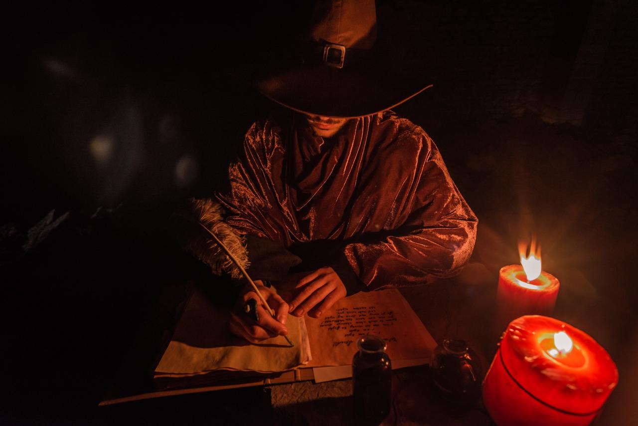 A symbolic depiction of a fortune teller writing prophecies by candlelight. (Adobe Stock Photo)