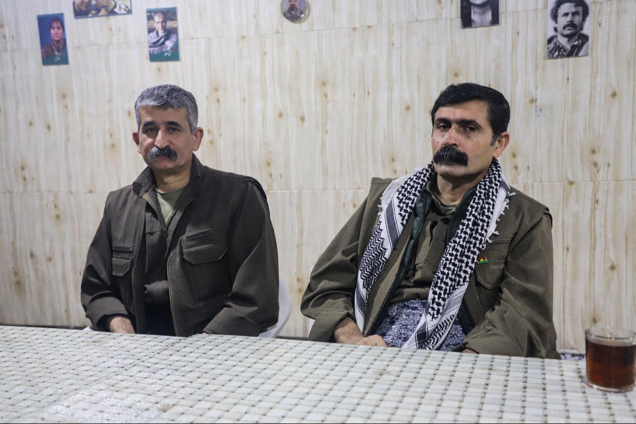 Mazlum Haftan (R) commander in the Kurdish Iranian armed faction, the Party of Free Life of Kurdistan (PJAK), sits next to Rewar Awdanan, a leader in the PJAK, at a site near the Iraqi border with Iran on February 26, 2026. (AFP Photo)