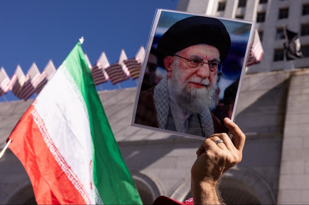 A protester holds a portrait of Iran's late supreme leader Ali Khamenei and a flag of Iran during a demonstration against the war in Iran in front of City Hall in Los Angeles, California, US on February 28, 2026. (AFP Photo)