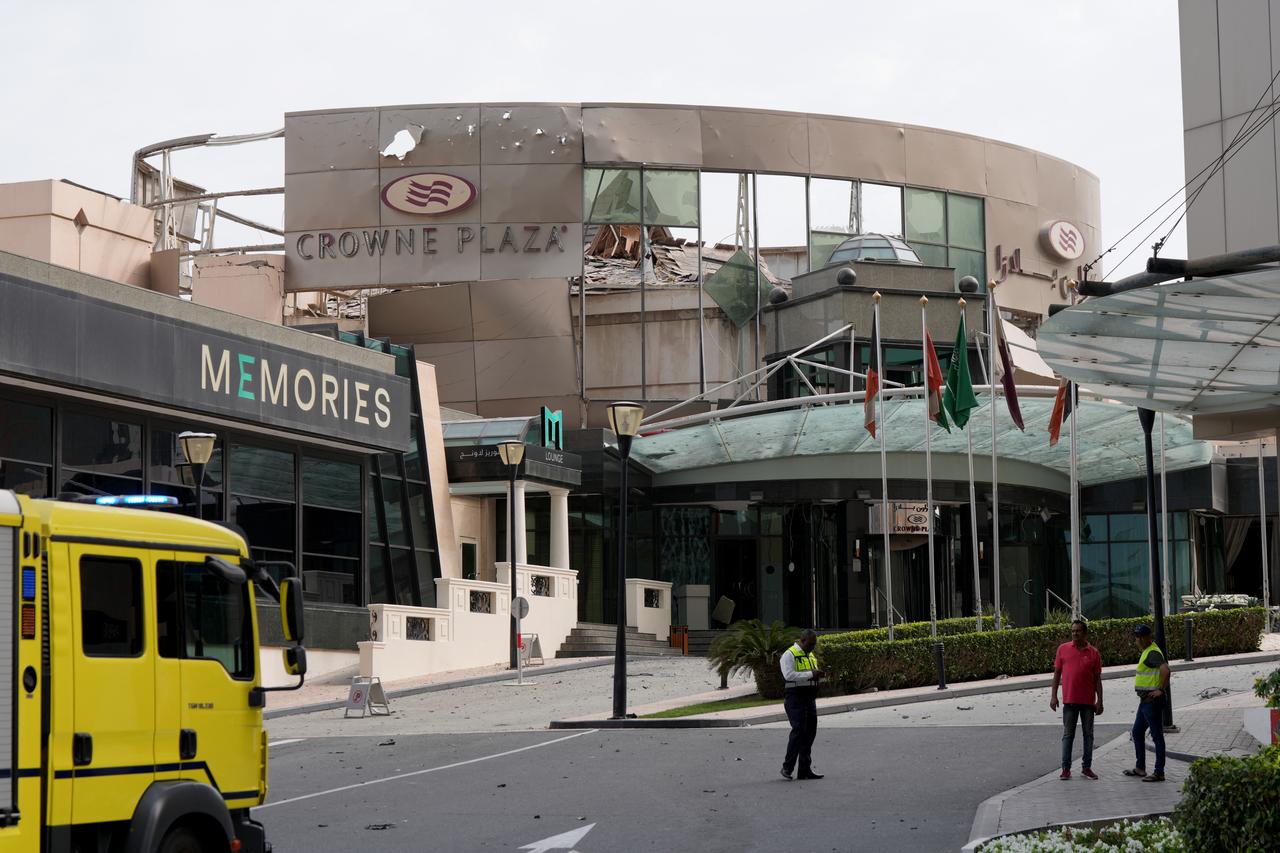 Security and civil defence workers stand outside the damaged Crown Plaza hotel, following an Iranian military strike, in Manama, March 1, 2026. (AFP Photo)