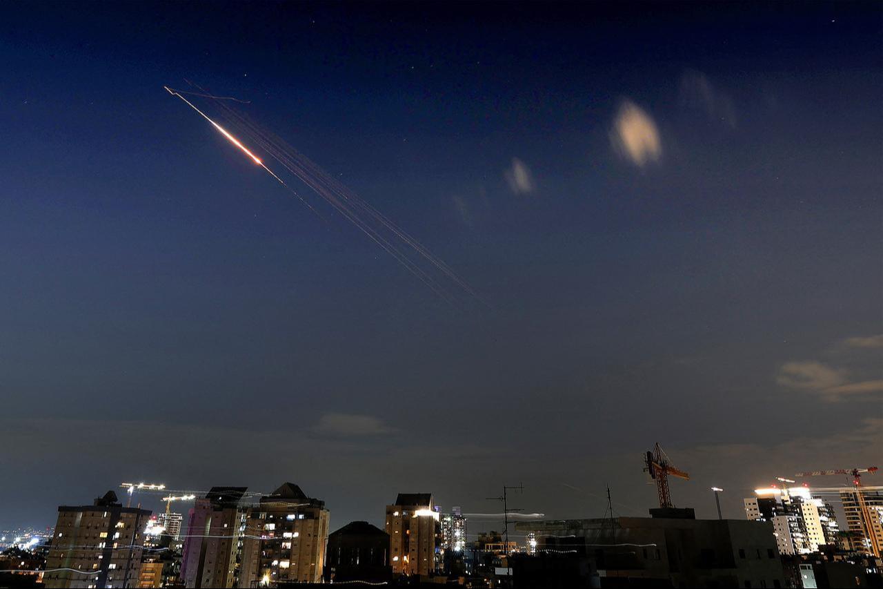 Rocket trails are seen in the sky above Netanya on March 7, 2026. (AFP Photo)