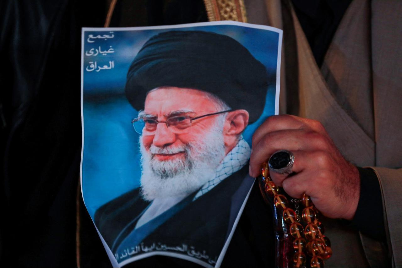 A Shiite Muslim man hold a poster of the late Iranian supreme leader Ali Khamenei, assassinated in a US- Israeli attack on Tehran, during a rally in Tahrir Square, in Baghdad on March 6, 2026. (AFP Photo)