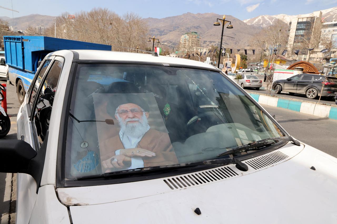 A poster with the image of Iran's slain supreme leader Ali Khamenei is placed in the front windshield of a vehicle parked close to Tajrish Square in Tehran on March 7, 2026. (AFP Photo)