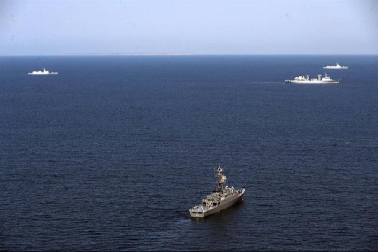 This handout picture provided by the Iranian Defence Ministry on March 12, 2024, shows (bottom) Iran Navy frigate IRIS Dena (75) at sea during the Maritime Security Belt 2024 combined naval exercise between Iran, Russia, and China in the Gulf of Oman. (AFP Photo)