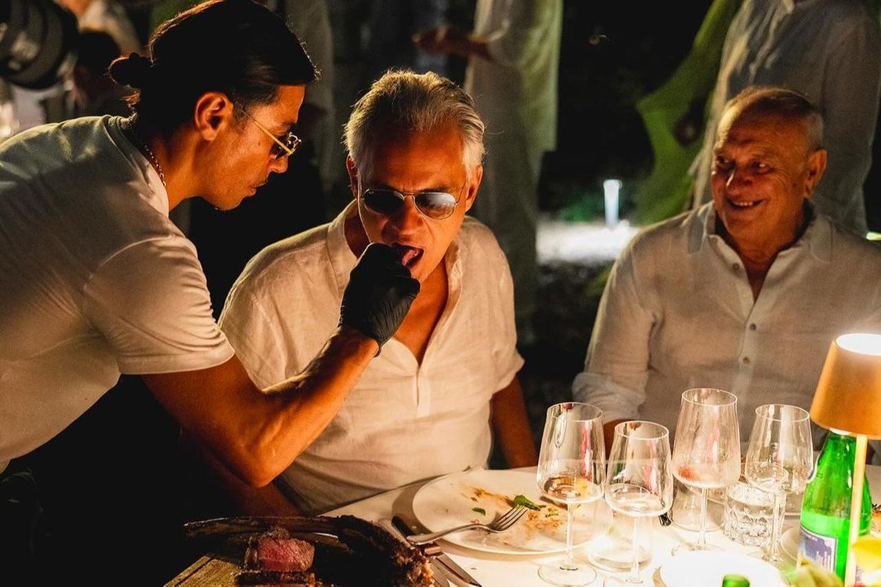 'Salt Bae' chef Nusret Gokce serves a piece of steak to renowned tenor Andrea Bocelli at Villa Alpebella, Forte dei Marmi, Italy. (Photo via Instagram / @alpemare_fortedeimarmi)