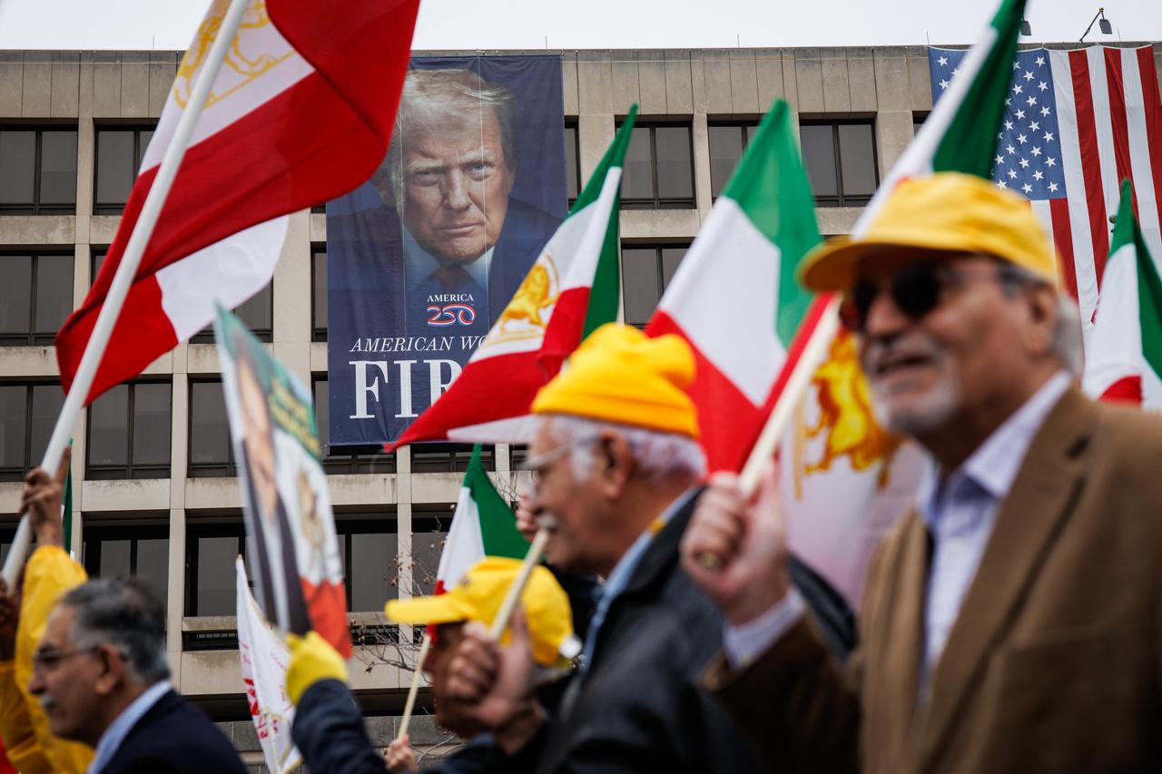 Demonstrators in favor of a regime change in Iran march past a banner depicting U.S. President Donald Trump on the side of the U.S. Department of Labor during a rally in support of the people of Iran on March 7, 2026 in Washington, DC. (AFP Photo)