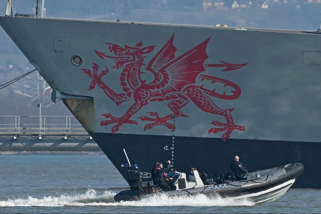 A Police patrol boat passes HMS Dragon, a Royal Navy Type 45 Daring-class air-defense destroyer warship on the south coast of England, March 4, 2026. (AFP Photo)