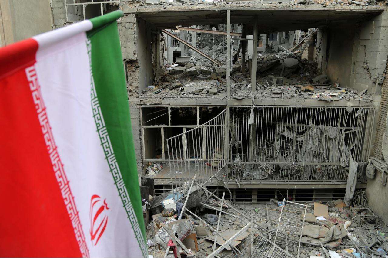A view of the Iranian flag with major destruction at Javadiyeh and Beryanak districts as a result of US-Israeli attacks in Tehran, Iran, on March 15, 2026. (AA Photo)