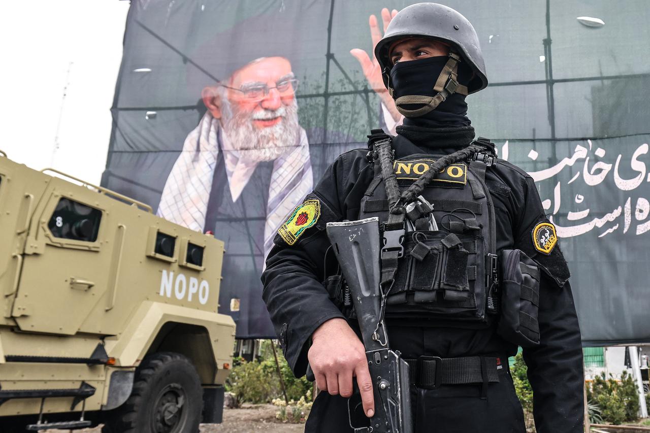 A member of the Iranian security forces stands guard next to a banner honouring Iran’s slain supreme leader Ali Khamenei in Tehran on March 31, 2026. (AFP Photo)