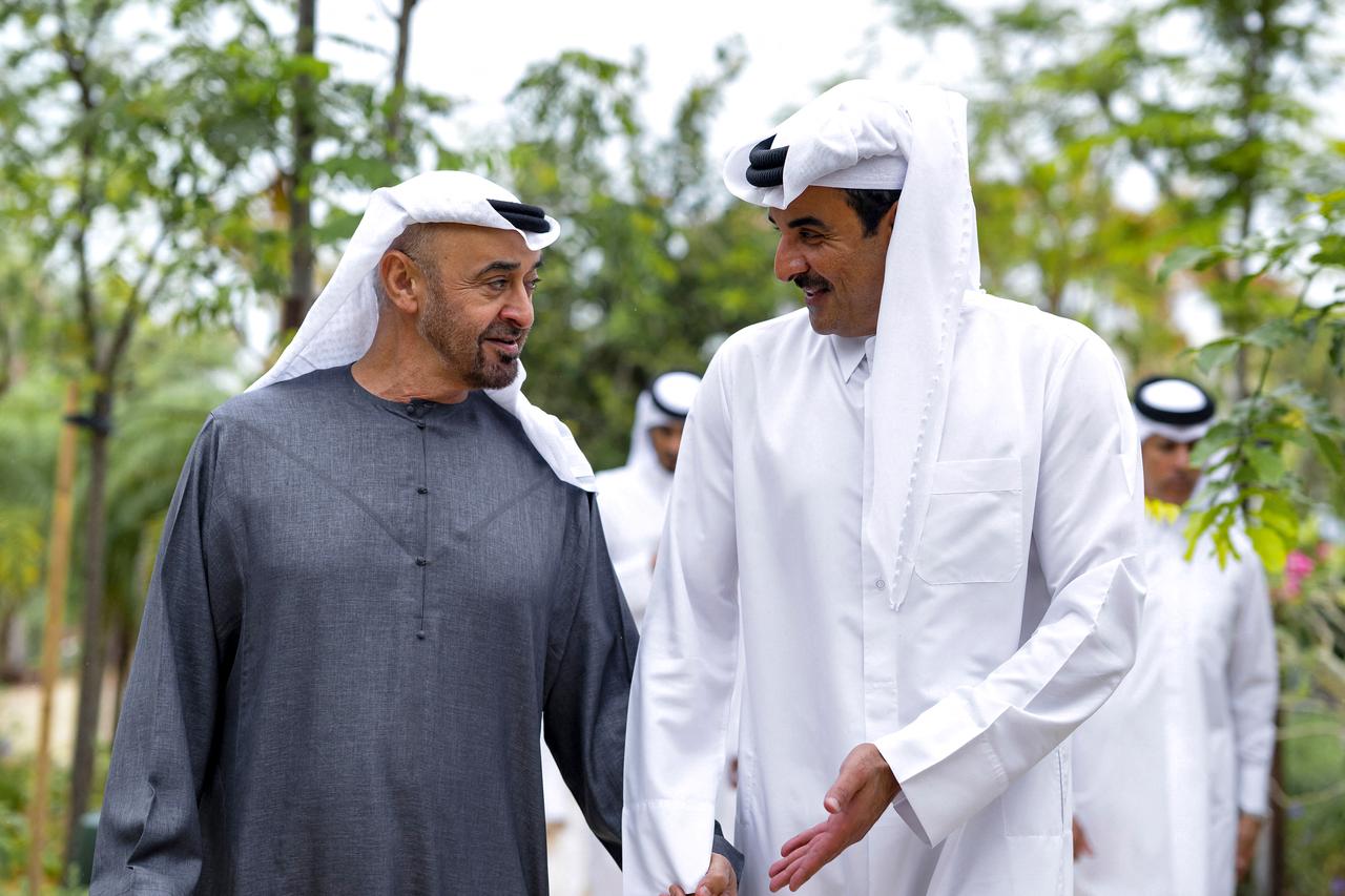 This handout picture shows UAE President Sheikh Mohamed bin Zayed Al-Nahyan (L) receiving Qatar's Emir Sheikh Tamim bin Hamad Al-Thani in Abu Dhabi, March 31, 2026. (Photo by Qatar Amiri Diwan / AFP)
