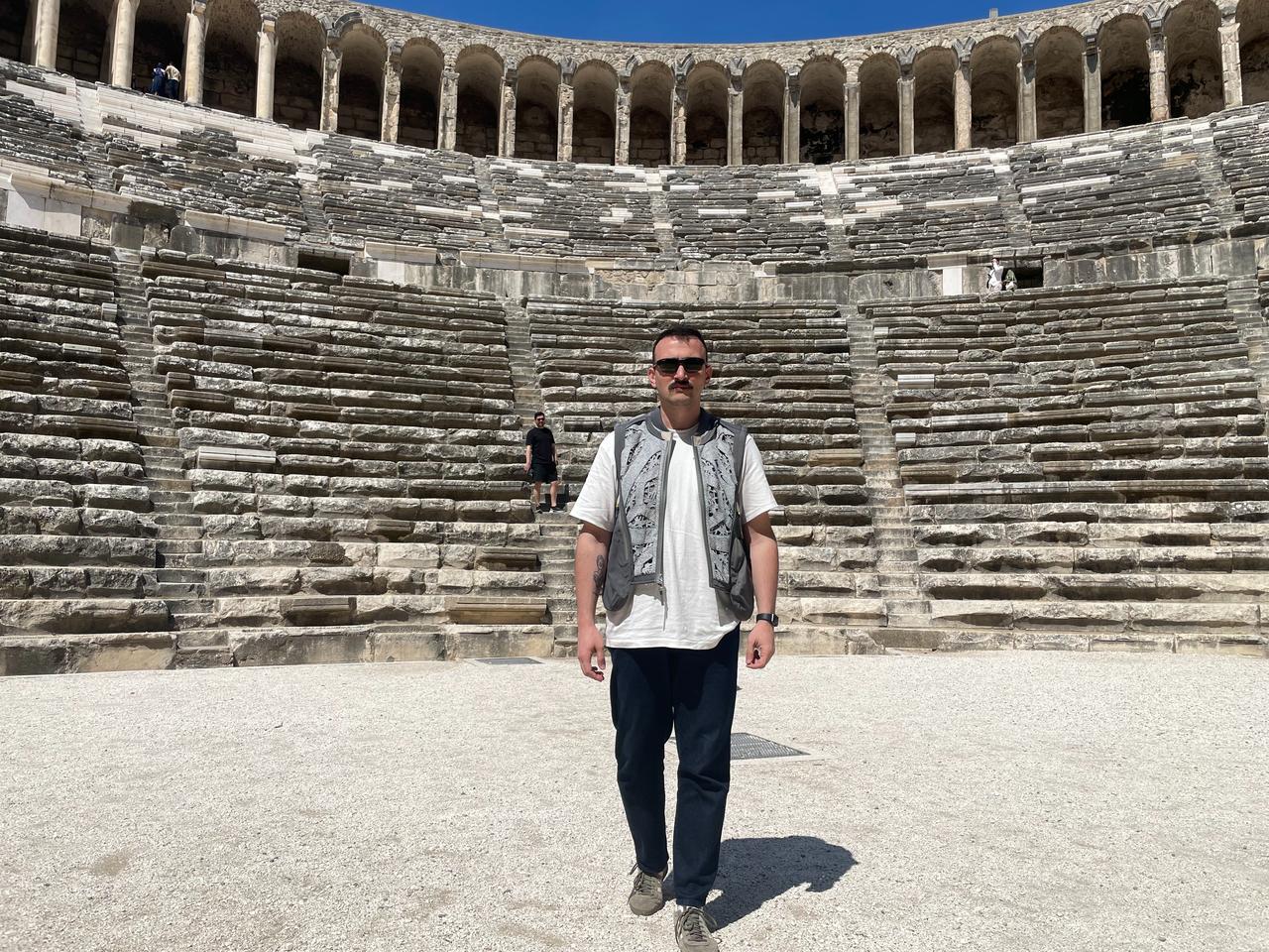 Journalist Koray Erdogan stands inside the Aspendos Ancient Theater in Antalya, Türkiye, April 8, 2026. (Photo by Türkiye Today team)