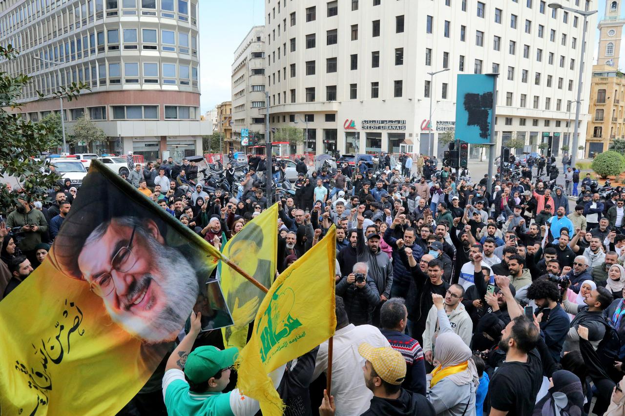 Hezbollah supporters wave a flag bearing a portrait of slain Hezbollah leader Hassan Nasrallah as they stage an anti-government protest outside the Lebanese governmental palace in Beirut, April 9, 2026. (AFP Photo)