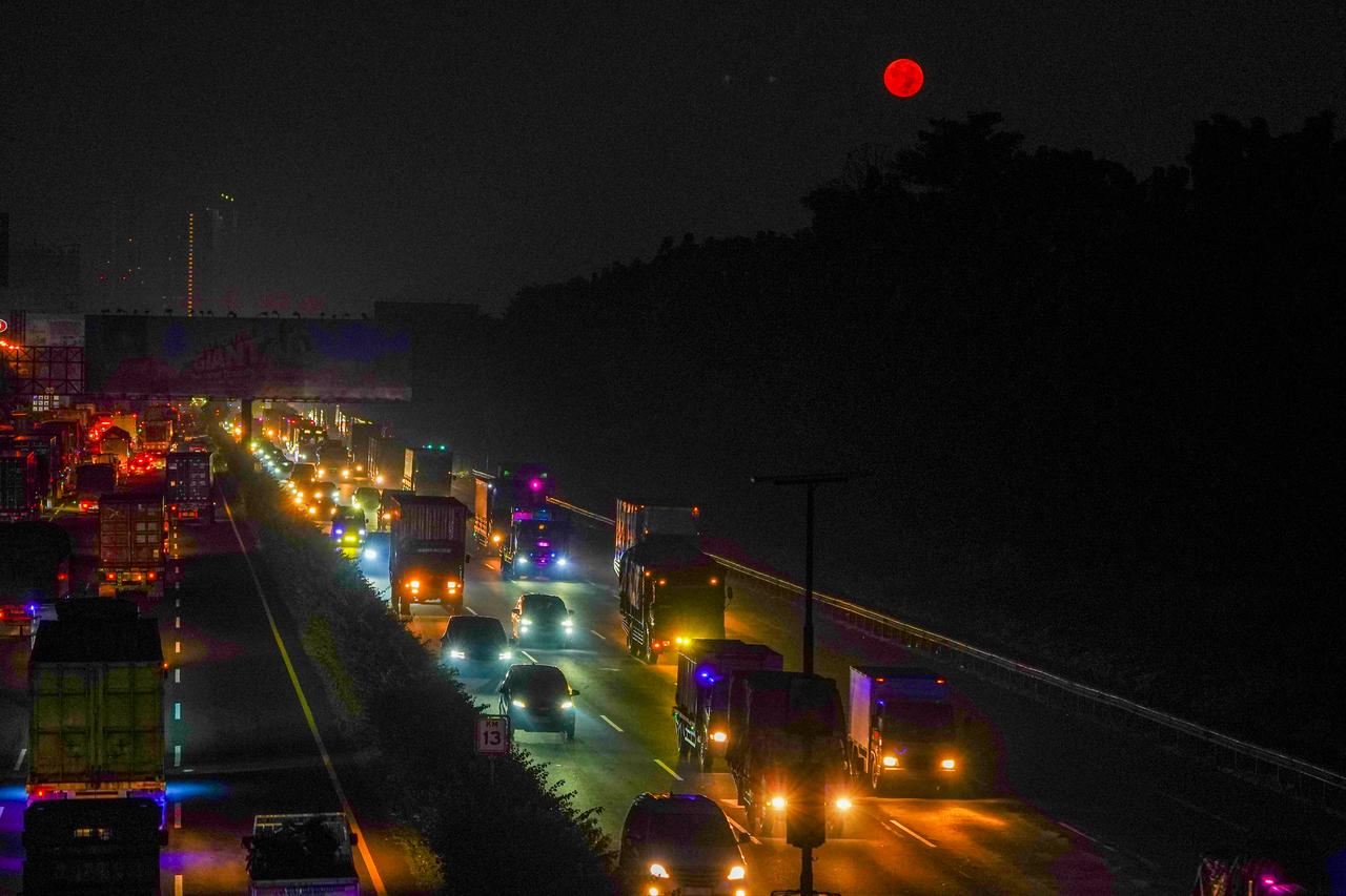 The "Pink Moon" rises over a highway in Tangerang, Indonesia, April 2, 2026. (AA Photo)