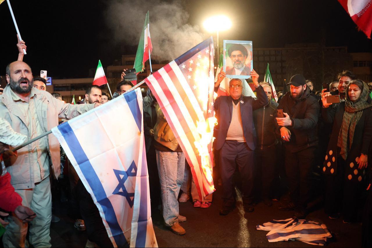 Iranians burn US and Israeli flags as react after the ceasefire announcement at the Enqelab square, in Tehran, Iran on April 8, 2026. (AFP Photo)