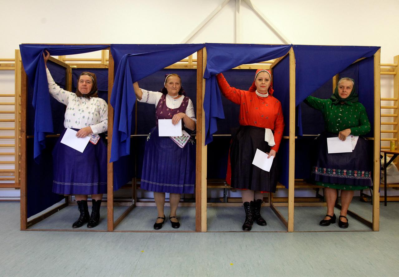 Women in traditional Hungarian dresses fill out their ballot papers at a polling station in a nursery school in Veresegyhaz, some 30km east of Budapest, on April 12, 2026. (AFP Photo)