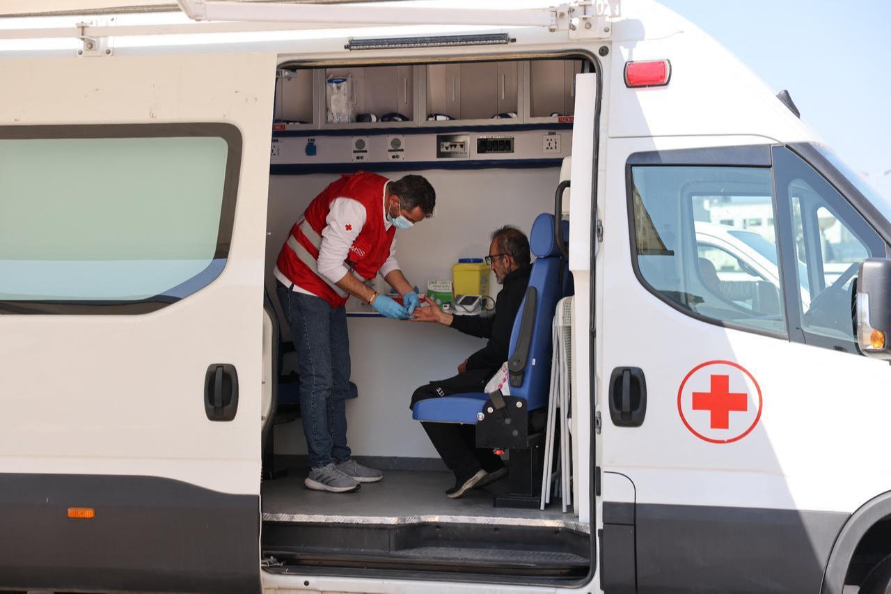 A Lebanese Red Cross volunteer tends to a displaced resident at the Camille Chamoun Sports City stadium, which was converted into a reception and shelter facility for displaced people, in Beirut on March 10, 2026. (AFP Photo)