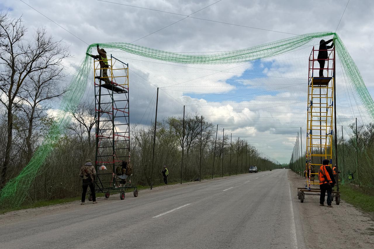 Ukrainian servicemen cover the road with a net to protect vehicles from drone attacks at an undisclosed location in the Zaporizhzhia region on April 10, 2026. (AFP Photo)