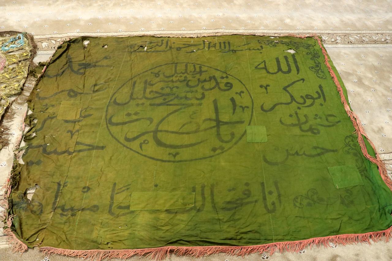 A centuries-old green banner bearing Arabic inscriptions and religious phrases is preserved despite visible wear in Karakaya neighborhood, Kayseri, Türkiye. (AA Photo)