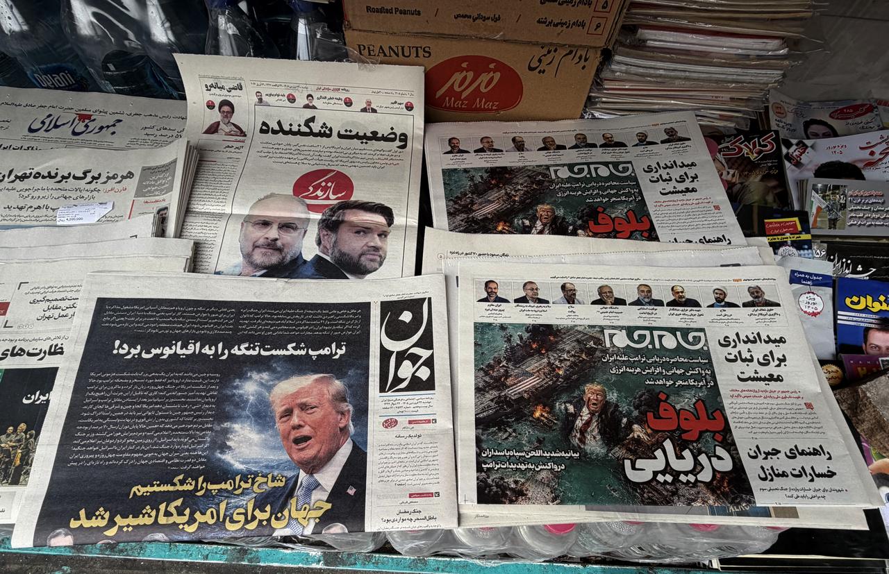 The front page of the Javan newspaper (L) and the front page of the Jam Jam newspaper, which features a cartoon of US President Donald Trump drowning in the Strait of Hormuz with the headline “Marine Bluff,” are on sale at a newsstand in Tehran on April 13, 2026. (AFP Photo)