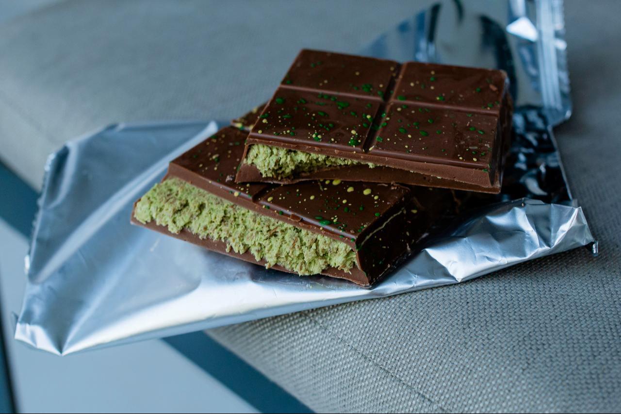A pistachio-filled milk chocolate bar pictured unwrapped. (Adobe Stock Photo)