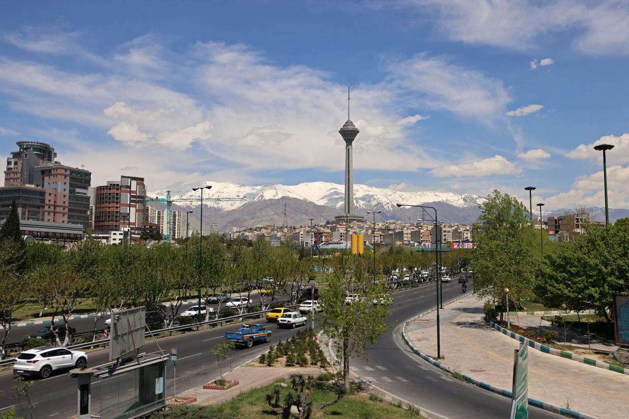 Motorists drive along a busy street past the Milad Tower (C) in Tehran on April 11, 2026. (AFP Photo)