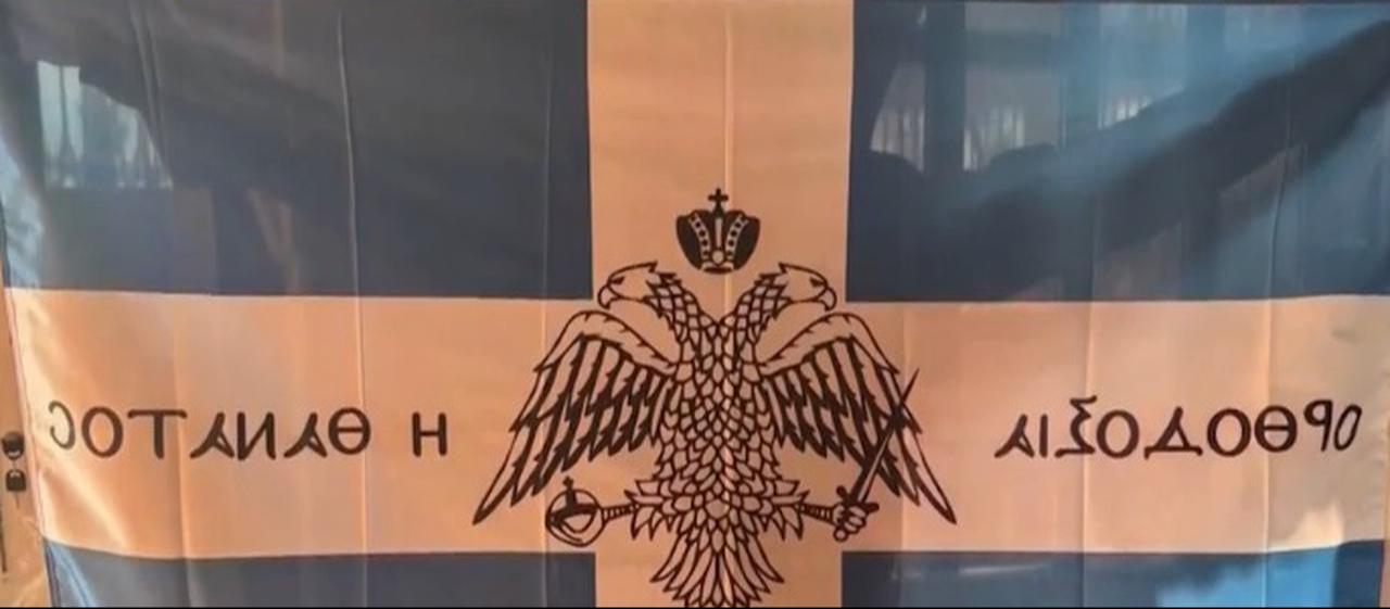 A flag, featuring the Byzantine double-headed eagle symbol, bearing the slogan “Orthodoxy or death!” is displayed in footage linked to the incident at Hagia Sophia, Istanbul, Türkiye. (Photo via NTV)